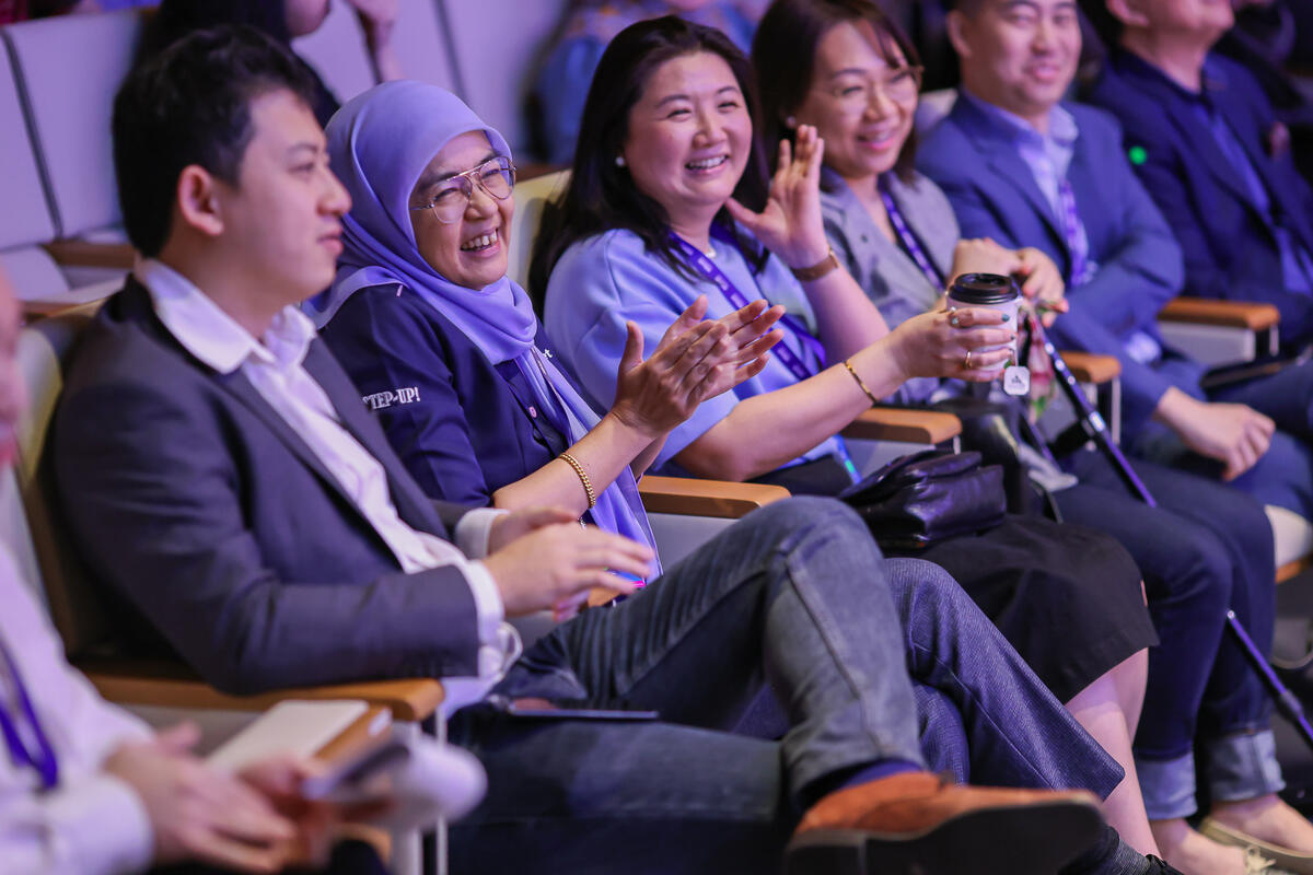 Attendees laughing and applauding in the front rows